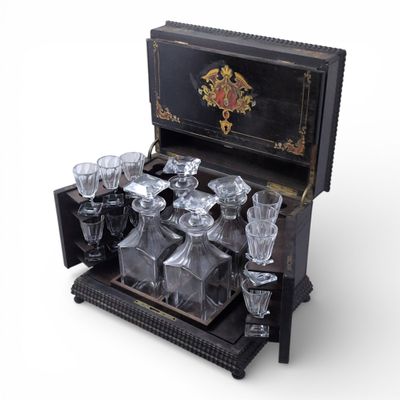 CAVE A LIQUEURS en bois noirci et placage de laiton, compren…