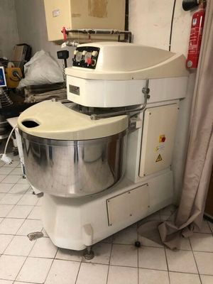 une photo d'un mixeur dans une cuisine, avec un ordinateur portable posé sur le plan de travail