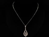 un collier en or blanc orné d'un pendentif en forme de larme serti d'un diamant, sur fond noir