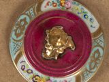 a plate with a gold bear on it on a table