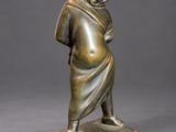 a bronze statue of a woman with a hood on her head