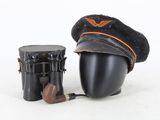 un chapeau, une pipe et un porte-pipe posés sur une surface blanche