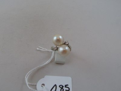 a white tag with two pearls attached to it