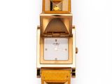 une image représentant une montre jaune dont le cadran est orné de pyramides