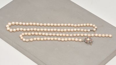 un gros plan sur un collier de perles blanches orné d'une étoile