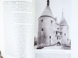 a person holding a book open to a picture of a castle