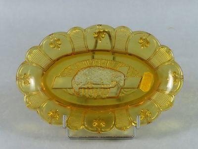 une assiette jaune posée sur un présentoir, sur laquelle se trouve un gâteau