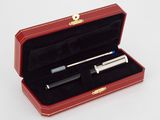 une boîte rouge contenant un stylo et un stylo
