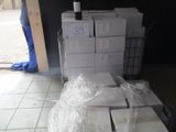 une pile de cartons et une bouteille de vin par terre