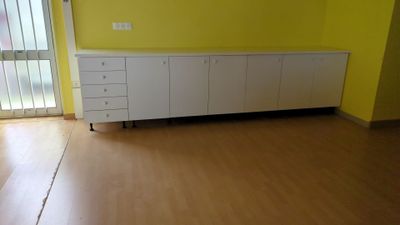 une armoire blanche dans un coin d'une pièce dotée d'une porte coulissante en verre