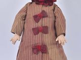 a small doll that is wearing a hat and dress