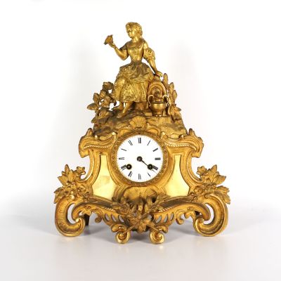 une horloge en or surmontée d'une statue