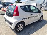 a small white car that is parked in a lot
