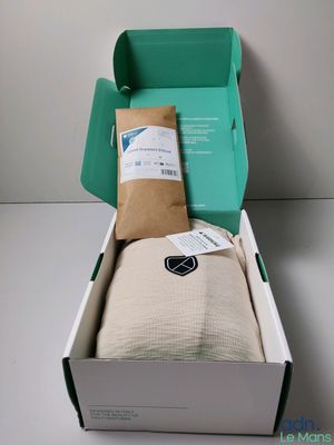 an open box with a blanket and a pillow inside of it