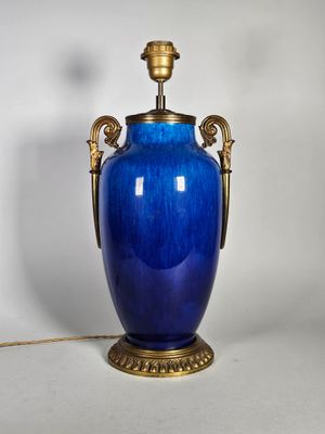 une image représentant un vase bleu muni d'une anse dorée sur fond blanc