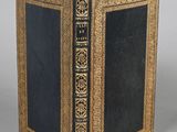 un vieux livre à la couverture noire posé sur une table