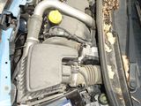 a blue car with its hood open and the engine in the trunk