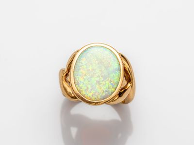 a yellow gold ring with an oplite stone in the center