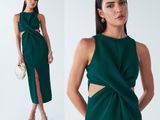 a woman wearing a green dress with a cut out front