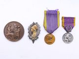 trois médailles et un ruban violet sur un fond blanc
