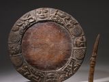 an image of a wooden plate with carvings on it next to a knife