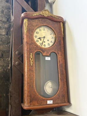 une horloge de parquet accrochée au mur à côté d'un escalier