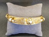 un gros plan sur un bracelet en or orné d'un cœur