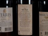 three bottles of wine are lined up on a shelf