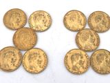 a close up of a bunch of gold coins on a white surface