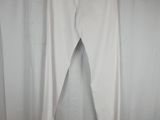 a pair of white pants hanging on a hanger in front of a white curtain
