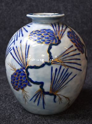 a blue and white vase with pinecones on it
