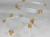 a pair of clear acrylic and brass coffee tables