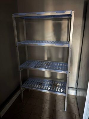 une étagère en métal dans un coin d'une pièce au sol carrelé