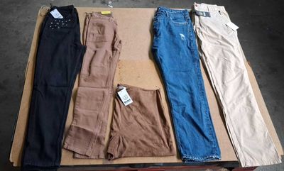 five pairs of pants sitting on top of a cardboard box