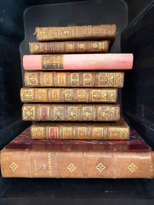 plusieurs vieux livres empilés les uns sur les autres sur une étagère