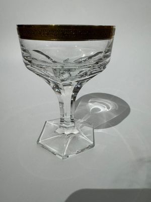 un verre à vin orné d'un bord doré posé sur une table