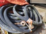 un tas de tuyaux et un sac rouge posés par terre