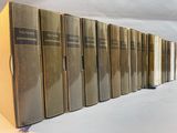 books lined up on a shelf in a row on a white surface