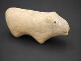 une image représentant une figurine d'animal en pierre posée sur une surface noire