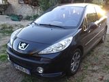 a picture of a small black car parked on the side of the road