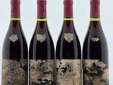 trois bouteilles de vin rouge sont alignées sur une table