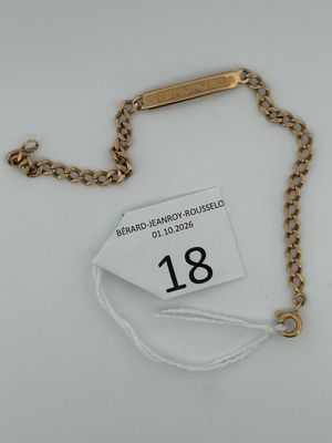 a close up of a gold chain with a tag on it