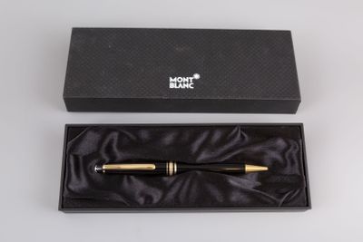 a black and gold pen in a black box on a white surface