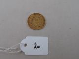 a gold coin and a white tag on a table