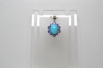 boucles d'oreilles en forme de fleurs turquoise et violettes, présentées dans un présentoir en acrylique transparent