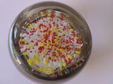 brightly colored sprinkles in a glass jar on a white surface