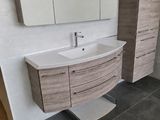une salle de bains équipée d'un lavabo, d'un miroir et de placards