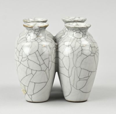 une paire de vases blancs présentant des craquelures sur une surface grise