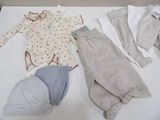 a baby ' s clothes and a hat on a table
