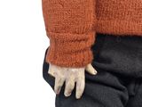 a close up of a doll wearing a sweater and pants